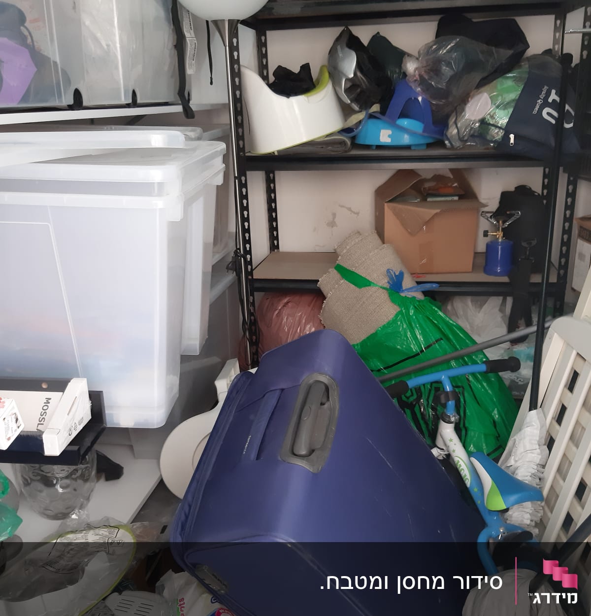 חדר מבולגן עם קופסאות פלסטיק ומזוודה כחולה